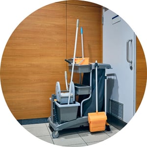 Janitorial cart sitting outside an airport restroom.