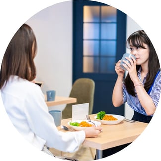 Female colleagues enjoying conversation at the lunch table.