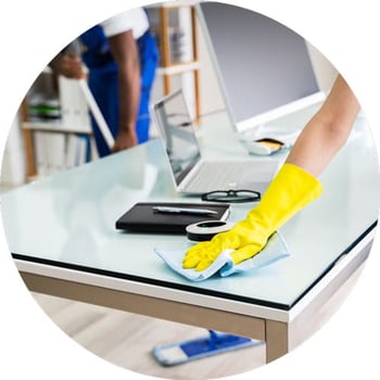 Janitor Sanitizing a Desk in an Office Building