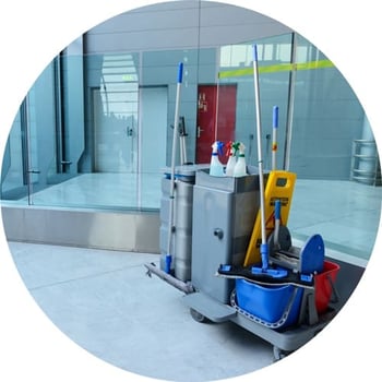 Janitorial cart sitting outside of an airport restroom.